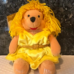 May include: Yellow plush Winnie the Pooh dressed as a yellow princess with a gold belt and long yellow hair. The tag says "Especially For".