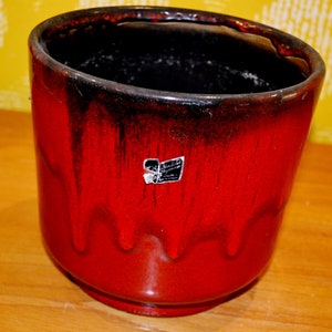 Puede incluir: Maceta de cerámica roja y negra con efecto de glaseado de goteo. La maceta tiene una pegatina que dice "Scheurich Germany".