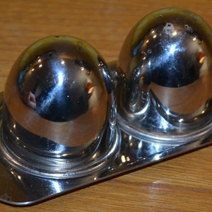 Puede incluir: Un juego de dos saleros y pimenteros de plata con una bandeja de plata a juego. Los saleros son redondos y tienen un acabado brillante.