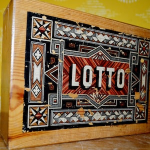 May include: A wooden box with a colorful geometric design and the word "LOTTO" printed in white letters on a red background.