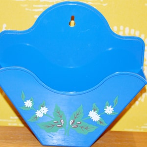 May include: Blue plastic coffee filter holder with a white floral design and a hole for hanging.