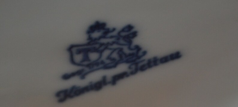 May include: A blue and white porcelain mark with the text "T. & J. Tettau" and a stylised image of a lion.