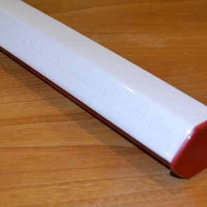 May include: A white, octagonal, plastic container with a red lid. The container has the text "Spare Auto Parts Butane Lighter" printed on it.