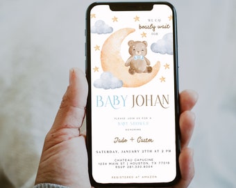 Può includere: Un invito a un baby shower con un'illustrazione ad acquerello di un orsacchiotto marrone con un fiocco blu seduto su una mezzaluna gialla. Il testo "Baby Johan" è in lettere blu e dorate. L'invito include la data, l'ora e il luogo del baby shower, nonché i nomi dei futuri genitori, Jade e Carter. L'invito include anche il testo "Registered at Amazon".