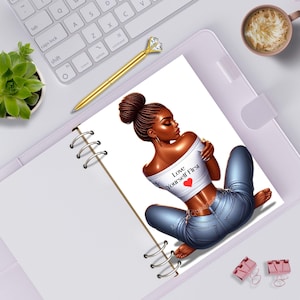 May include: A spiral-bound notebook page featuring an illustration of a person with braided hair in a bun, wearing a white off-the-shoulder top with the text Love Yourself First and a red heart, paired with blue jeans, sitting in a relaxed pose.