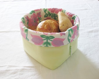 Könnte beinhalten: Ein gelber Stoff-Brotkorb mit einer floralen Futter. Der Korb ist mit Brötchen gefüllt.