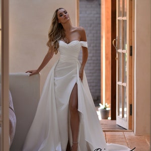 elegante 80er Kleider für Frauen, weißes Kleid mit Wasserfall Ausschnitt  und schwarzem Gürtel, schulterfre…