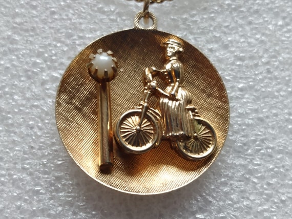 Gold tone woman on a bicycle pendant with genuine… - image 1