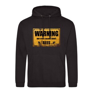 May include: Black hooded sweatshirt with a yellow warning sign that says "Warning May Start Talking About Bees" with a rusty look and bee illustrations.