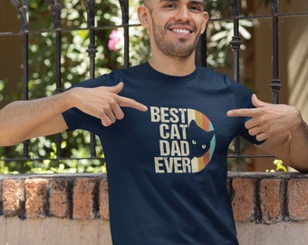 May include: A navy blue t-shirt with a retro-style graphic that says "Best Cat Dad Ever" with a black cat silhouette in a circle.