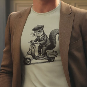 May include: A light green t-shirt featuring a black and white illustration of a squirrel wearing a cap and riding a scooter. The scooter has the text "MOD-TERROR" on the side.