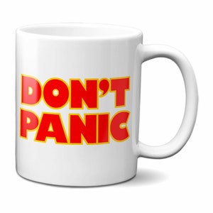 May include: White ceramic mug with a red and yellow graphic that says "DON'T PANIC".