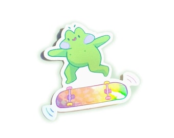 Peut inclure: Une grenouille verte avec une expression joyeuse saute sur une planche à roulettes arc-en-ciel. La planche à roulettes a des roues roses et des trucks noirs.