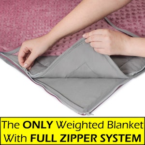 May include: A pink weighted blanket with a full zipper system. The zipper is open and the gray inner lining is visible.
