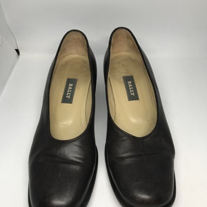 May include: A pair of black leather Bally pumps with a square toe.