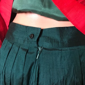 May include: A dark green skirt with a zipper closure and a button at the waist.