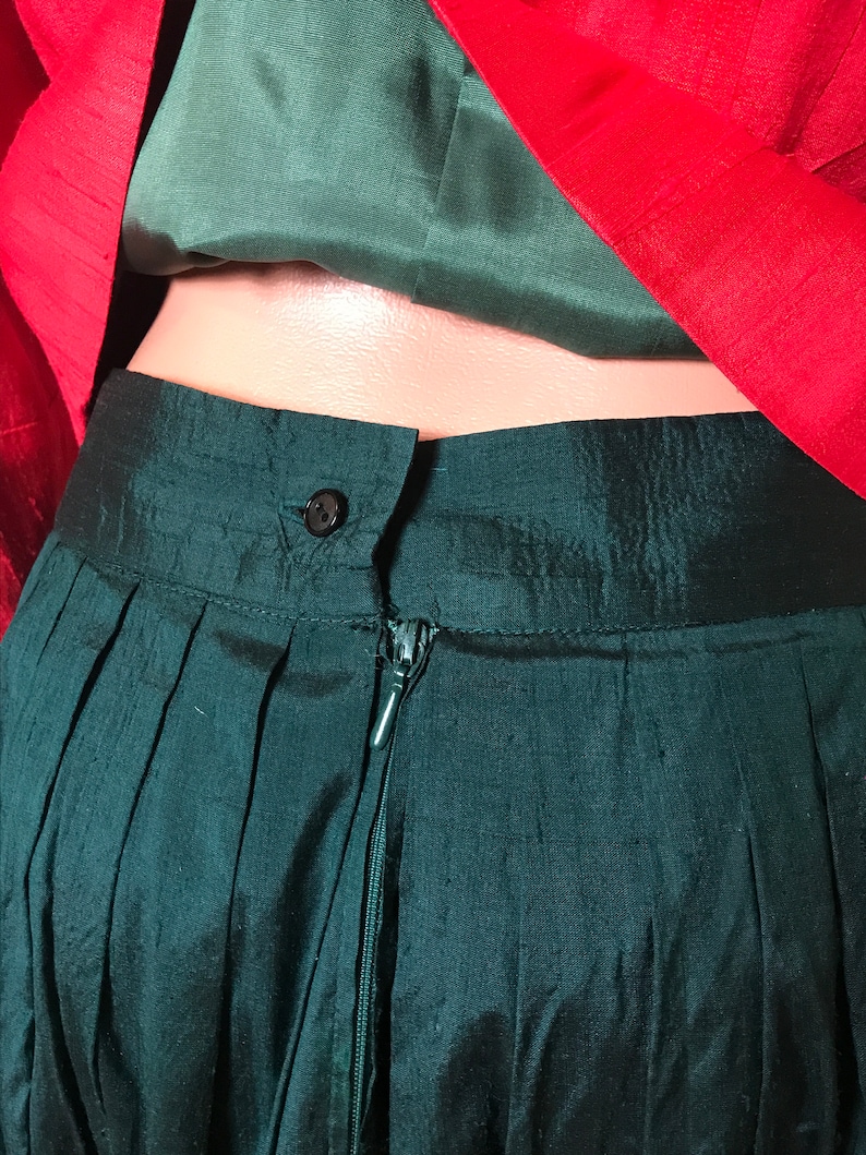 May include: A dark green skirt with a zipper closure and a button at the waist.