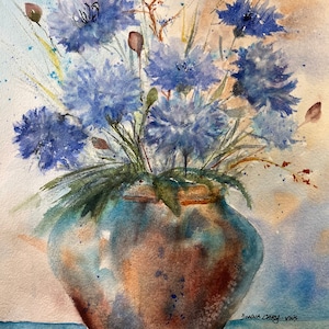 May include: Watercolor painting of a bouquet of blue flowers in a brown and blue vase. The flowers have a soft, textured appearance, with green stems and leaves. The vase is round with a wide base. The background is a blend of light blue and brown.