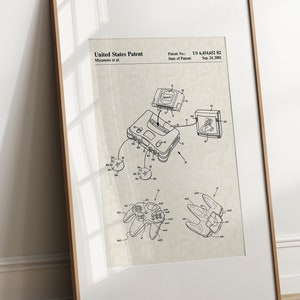 May include: A black and white line drawing of a Nintendo 64 console and controller. The drawing is on a beige background with the text "United States Patent" and "Patent No.: US 6,454,623 B2" at the top. The drawing shows the console with a game cartridge inserted and a controller connected. The drawing also shows a television screen with a video game image.