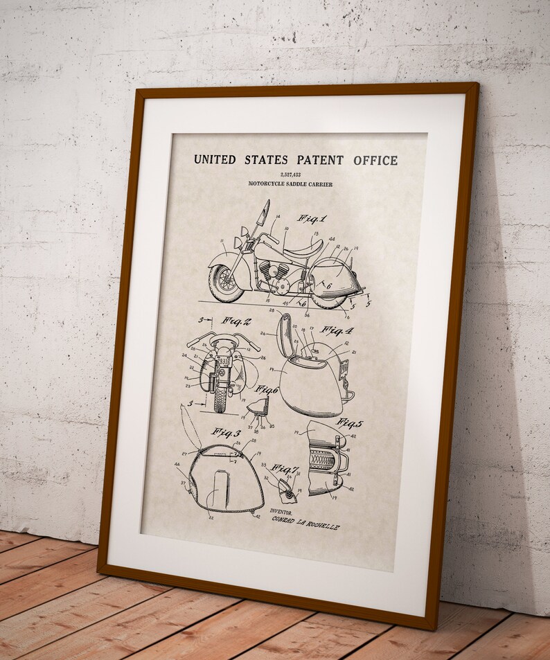 May include: A black and white line drawing of a motorcycle saddle carrier patent. The patent drawing shows a motorcycle with a saddle carrier attached to the back. The drawing includes multiple views of the saddle carrier, showing its design and features. The patent number is 2,857,412 and the inventor is Conrad La Rochelle.