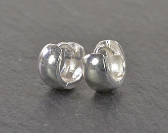 May include: A pair of silver hoop earrings. The earrings are smooth and have a polished finish.