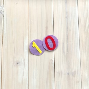 Distintivos numerados adicionais, zero e um, para acompanhar as coroas de aniversário.