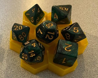 Può includere: Un vassoio per dadi esagonale verde con un vassoio per dadi esagonale giallo pieno di dadi verdi e dorati.