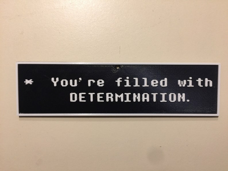 May include: A black and white sign with a white border that reads "* You're filled with DETERMINATION."