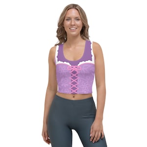May include: Purple crop top with a white lace trim and pink floral design. The top has a pink ribbon tied at the center.