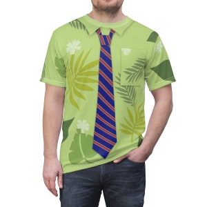 May include: A green short-sleeved shirt with a printed design of leaves and flowers. The shirt has a blue and red striped tie printed on the front.
