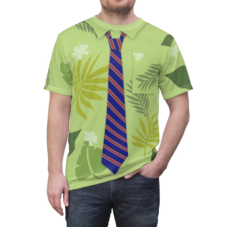 May include: A green short-sleeved shirt with a printed design of leaves and flowers. The shirt has a blue and red striped tie printed on the front.
