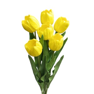 May include: A bouquet of six yellow tulips with green stems and leaves.