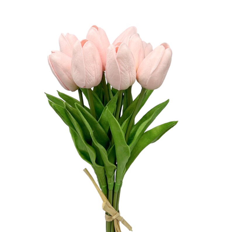 May include: A bouquet of pink artificial tulips with green leaves tied together with a brown ribbon.