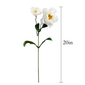 May include: A white artificial flower arrangement with two large white flowers and green leaves. The flowers have yellow centers. The arrangement is 20 inches tall.