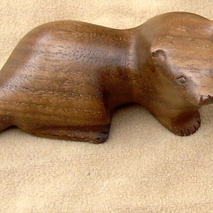 carved wooden otter in walnut. yew or spalted beech grey walnut