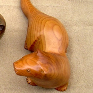 carved wooden otter in walnut. yew or spalted beech golden yew