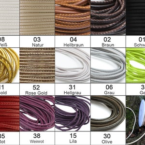 Puede incluir: Una colección de 12 carretes de cordón de cuero en varios colores, incluyendo blanco, marrón, negro, dorado, oro rosa, gris, amarillo, rojo, burdeos, morado, oliva y crema. Cada carrete está etiquetado con un número y un nombre de color en alemán.