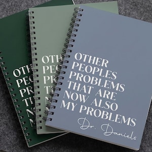 May include: Three spiral-bound notebooks in dark green, sage green, and slate blue. Each cover features the white text "OTHER PEOPLES PROBLEMS THAT ARE NOW ALSO MY PROBLEMS" and the name "Dr. Daniels" in a white script font at the bottom.