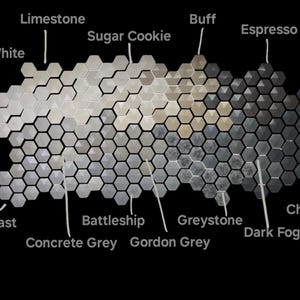 Op de afbeelding: Een kleurenpalet van zeshoekige tegels, vari&euml;rend van Bone White tot Charcoal. De tegels zijn gelabeld met namen als Limestone, Sugar Cookie en Concrete Grey. De achtergrond is zwart.