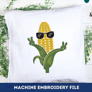 Puede incluir: Diseño de bordado a máquina de una mazorca de maíz con gafas de sol y haciendo un signo de paz. La mazorca de maíz es amarilla y verde y tiene un fondo blanco.