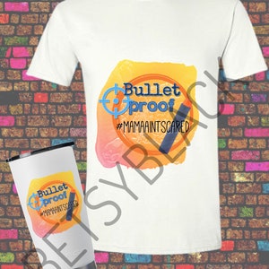 May include: White t-shirt with a yellow, orange, and pink watercolor design that says "Bulletproof #MamaAintScared". A white tumbler with the same design is also shown.