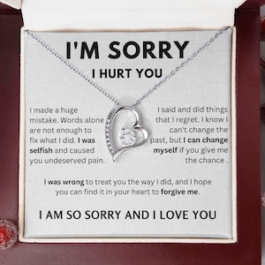May include: A silver necklace with a heart pendant that says "I'm Sorry I Hurt You". The necklace comes in a wooden box with a message of apology inside. The message says "I made a huge mistake. Words alone are not enough to fix what I did. I was selfish and caused you undeserved pain. I said and did things that I regret. I know I can't change the past, but I can change myself if you give me the chance. I was wrong to treat you the way I did, and I hope you can find it in your heart to forgive me. I am so sorry and I love you."