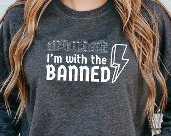 May include: A dark gray sweatshirt with a white graphic design that says "I'm with the BANNED" with a lightning bolt next to it.
