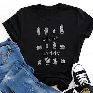 May include: Black t-shirt with a white graphic of various potted plants and the text "plant daddy".