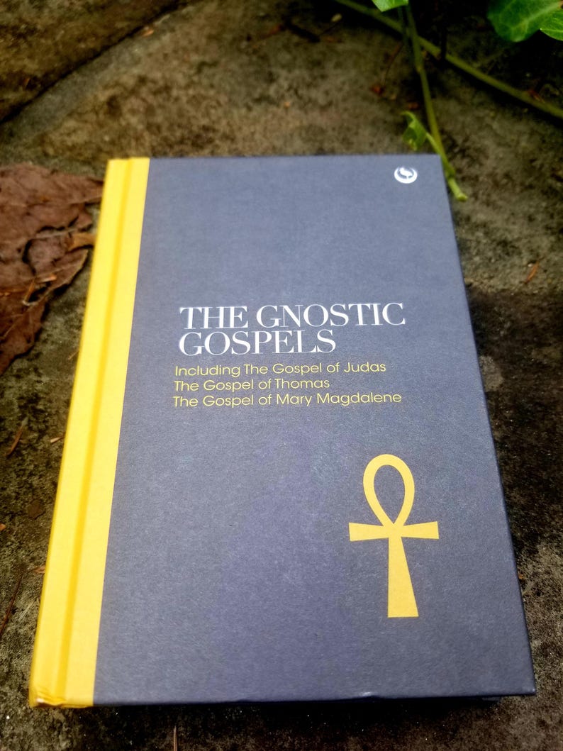 May include: A dark blue book with the title "The Gnostic Gospels" and a yellow ankh symbol on the cover. The book includes the Gospel of Judas, the Gospel of Thomas, and the Gospel of Mary Magdalene.