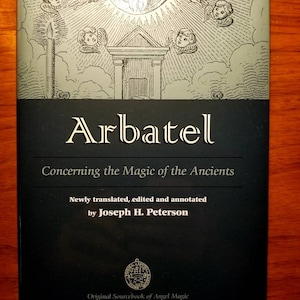 May include: A black book cover with the title "Arbatel: Concerning the Magic of the Ancients" and the author "Joseph H. Peterson". The cover features an illustration of a winged figure with a beard and a halo, surrounded by angels.