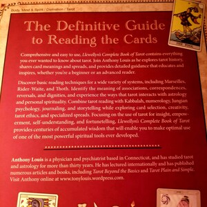 May include: The Definitive Guide to Reading the Cards book cover features a red background with gold text. The book title is "The Definitive Guide to Reading the Cards". The author is Anthony Louis. The book cover also features a tarot card image of "The Fool".