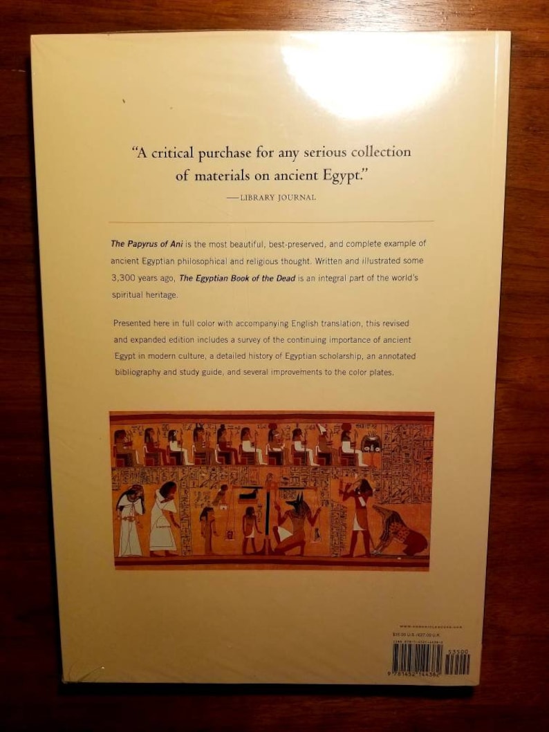 May include: The back cover of a book about the Papyrus of Ani, an ancient Egyptian philosophical and religious text. The cover features a quote from Library Journal, a detailed description of the book, and a colourful illustration of a scene from the Papyrus of Ani.