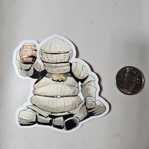May include: A white, cartoon-style knight wearing armor and holding a small barrel in one hand. The knight is sitting down with its legs crossed. The background is a plain white surface.