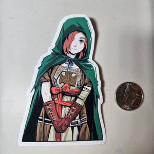 May include: A sticker featuring a cartoon illustration of a woman with red hair wearing a green hooded cloak and a brown and red outfit. She is holding her hands together in front of her.